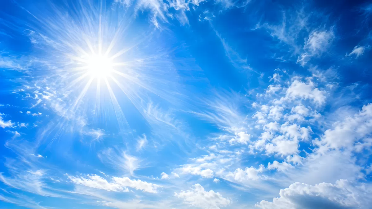 Strahlende Sonne am blauen Himmel mit Wolken