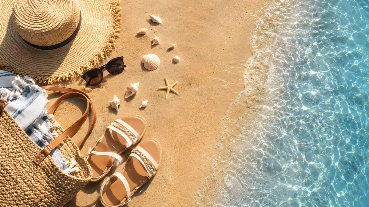 Strandaccessoires auf Sand am türkisblauen Meer