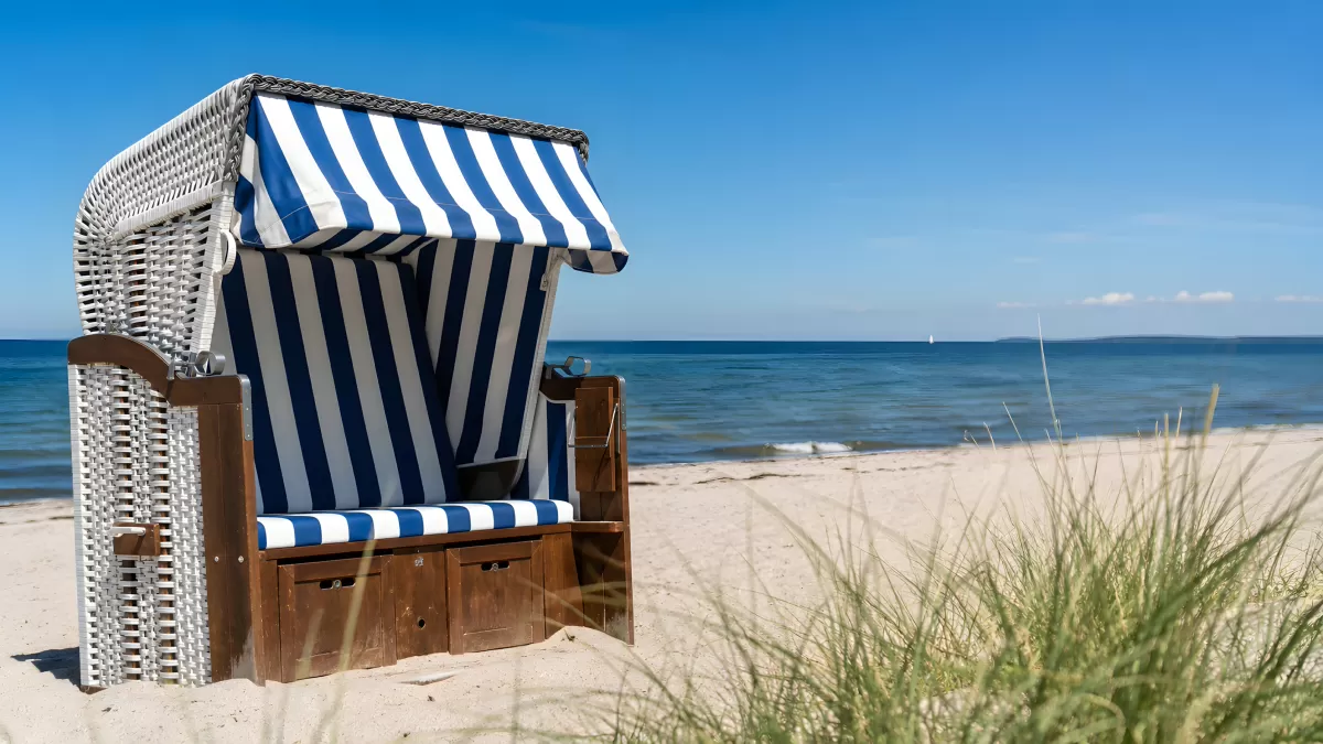 Strandkorb mit blau-weißen Streifen an der Ostsee