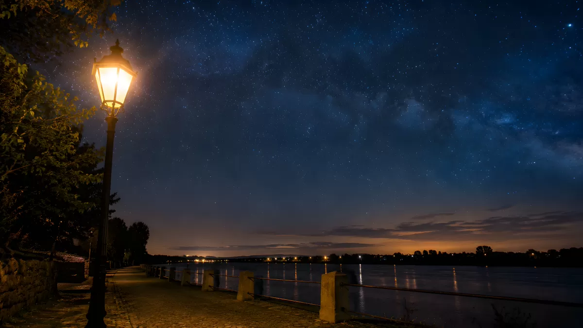Straßenlaterne an einem Flussufer unter Sternenhimmel