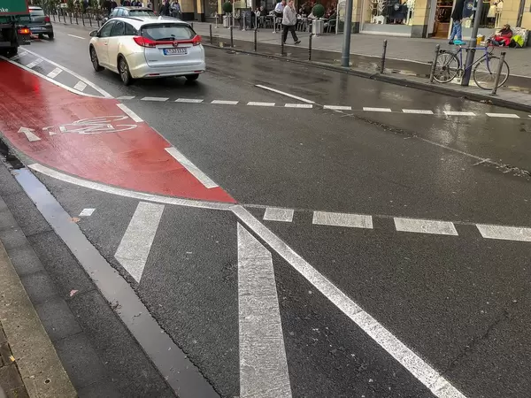Straße mit abgetrenntem Fahrradweg, der die Straße kreuzt