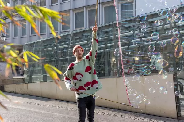 Straßenkünstler macht viele Seifenblasen