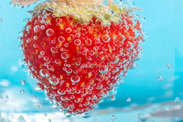 Strawberries on blue background with bubbles
