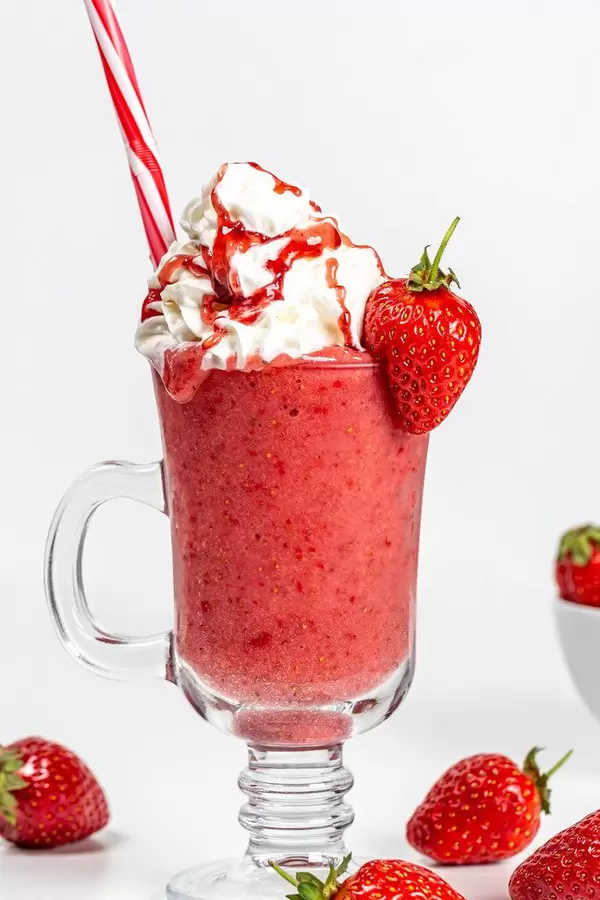 Strawberry smoothie with whipped cream and berry syrup
