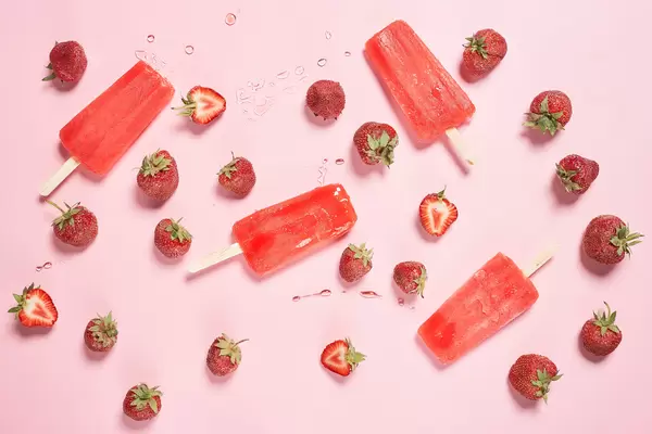 Strawberry vanilla ice cream popsicle on strawberry fruits