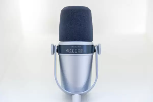 Streaming-Mikrofron Shure Model MV 7 Silver mit Halterung vor weißem Hintergrund