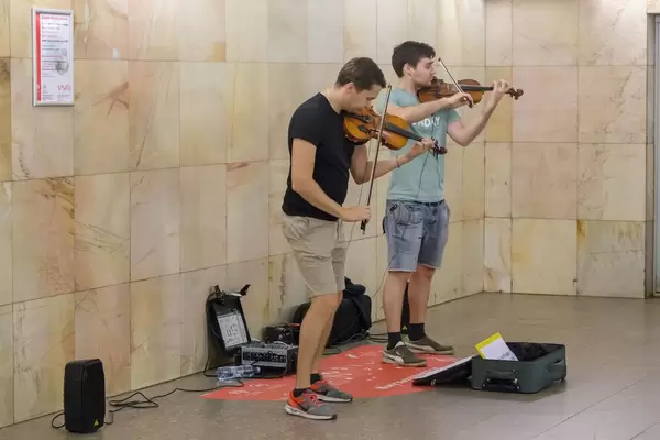 Street artist playing violins in Moscow Metro