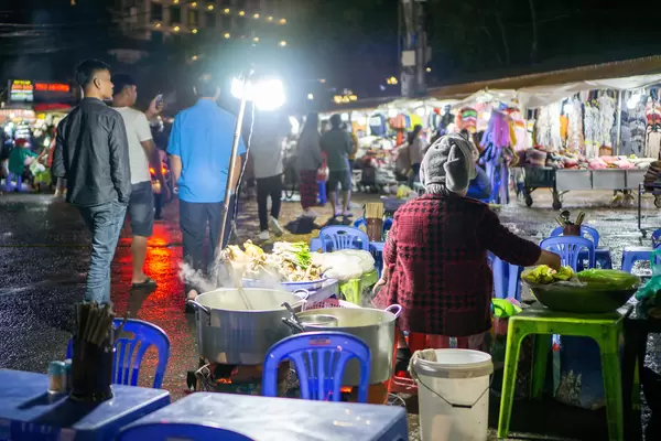 Street Food Noodle Soup in front of Clothing Stores at the Night Market in Dalat, Vietnam