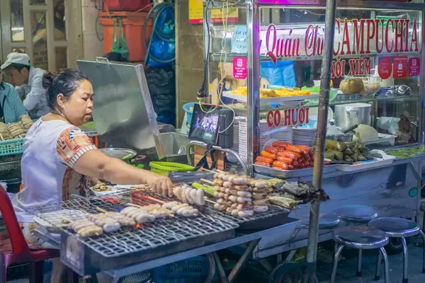 Streetfood Vendor selling grilled Bananas at a Market in Saigon