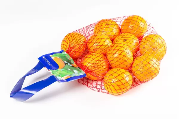 String bag with ripe tangerines on a white background