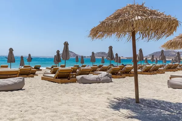 Strohschirm im Hawaii-Stil und viele geschlossene Sonnenschirme. Leerer Kalafati Strand auf Mykonos