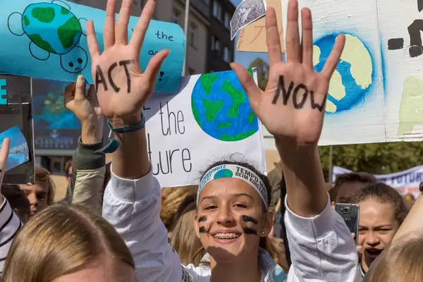 Student wrote "Act Now" on both hands to protest climate politics during climate strike