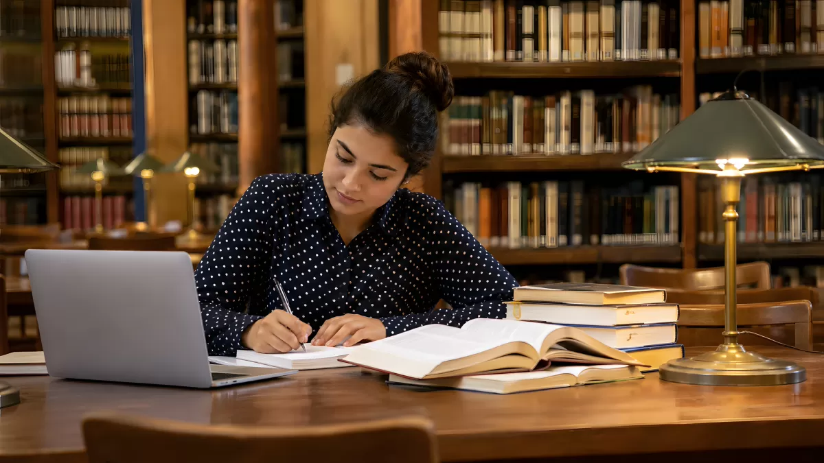 Studentin lernt konzentriert in klassischer Bibliothek