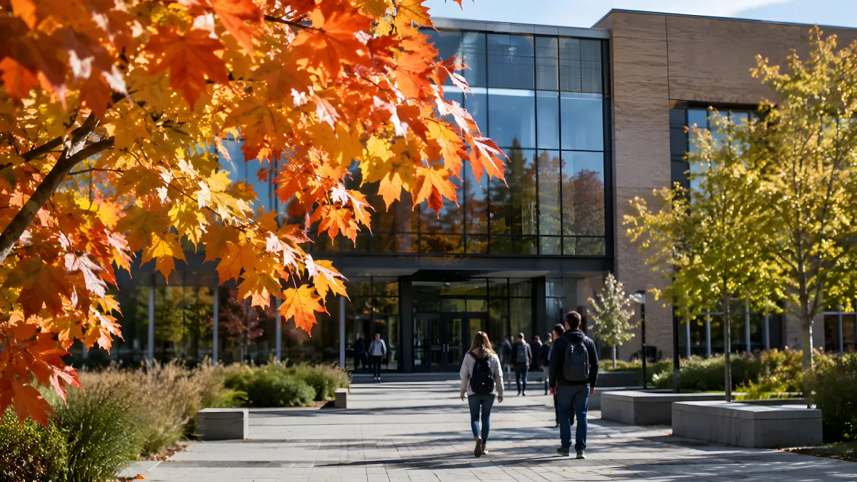 Studierende vor modernem Universitätsgebäude im Herbst