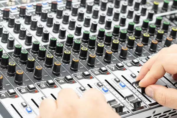 Studio engineer mixing with hands on Studio Mixer