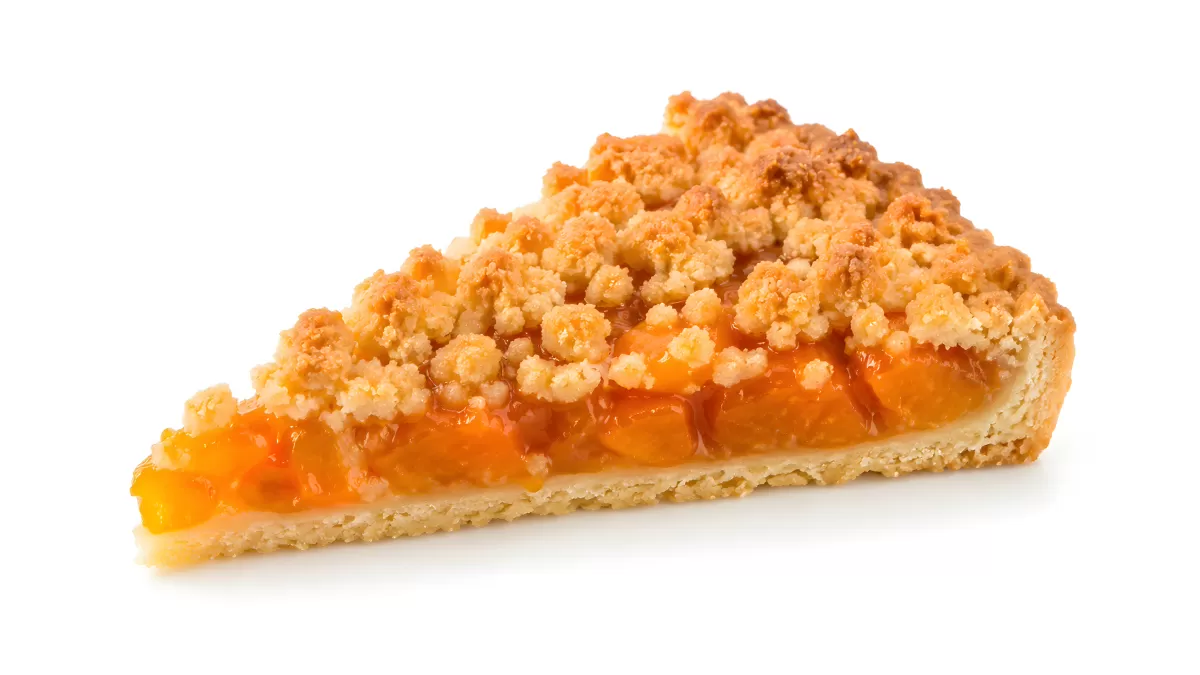 Stück Aprikosen-Streuselkuchen auf weißem Hintergrund