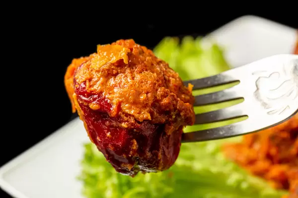 Stuffed bell peppers with meat, rice and tomato sauce on a fork, close-up