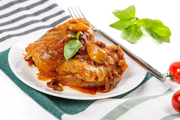 Stuffed cabbage rolls with tomato sauce on white plate