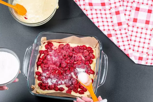 Sugar falls on the cherries. The process of preparing a berry pie