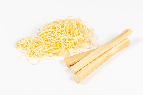 Suluguni cheese sticks and shavings on a white background