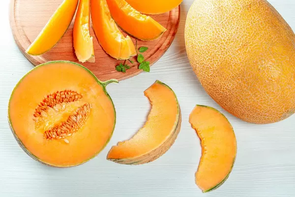 Summer background with ripe melons on white table