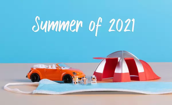 Summer of 2021 concpet with miniature people relaxing in deck chairs