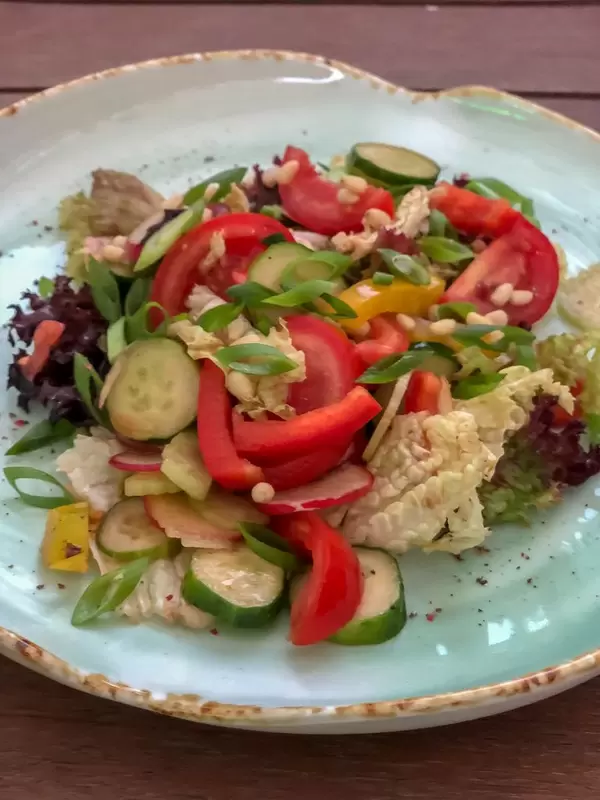 Summer salad at Avocado Cafe: tomatoes, cucumbers, sweet pepper, celery lettuce leaves, pine nuts, balsamic vinegar, olive oil, lemon juice