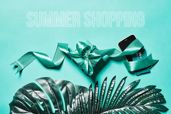 Summer shopping - palm leaves, credit card with smartphone and gift from the online store
