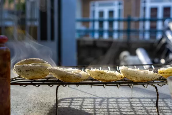 Sun Shining on Steaming Hot Vietnamese Rice Cakes Banh Can at a Street Food Restaurant in Da Lat, Vietnam
