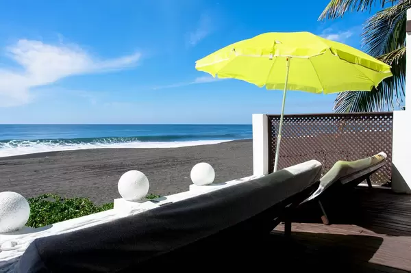 Sunbeds and green umbrella beside the beach