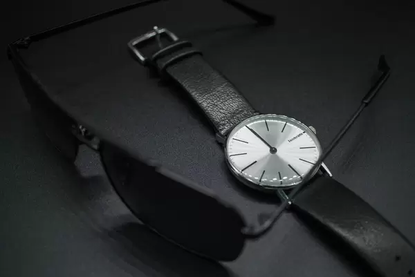 Sunglasses and black leather wristwatch. Formal wear accessories