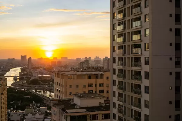 Sunset at Golden Hour with View of Saigon River, Apartment Buildings and Traffic Jam at Nguyen Van Cu Bridge in Ho Chi Minh City, Vietnam