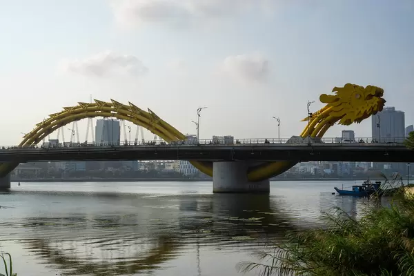 Sunset at the Iconic Dragon Bridge with Reflection in Han River with Buildings in the Background in Da Nang, Vietnam