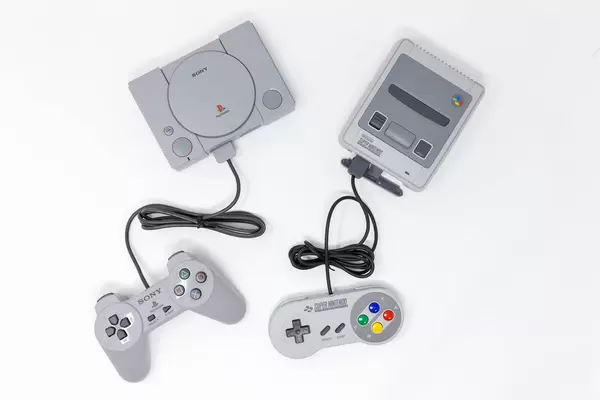 Super Nintendo und Playstation Classic Konsolen auf weißem Hintergrund