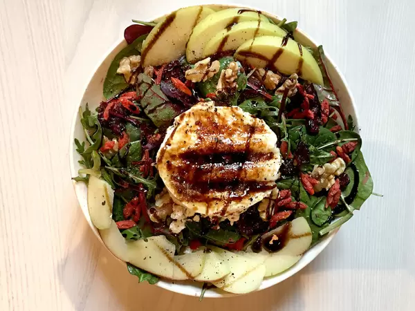 Superfood Salad Bowl mit Ziegenkäse, Apfel, Salat, Walnüssen und Cranberries.
