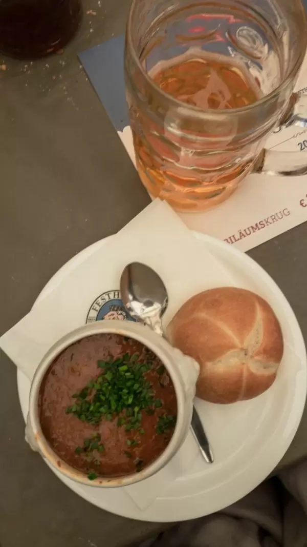 Suppe mit Brötchen und einem Maß Bier auf der Wiesn