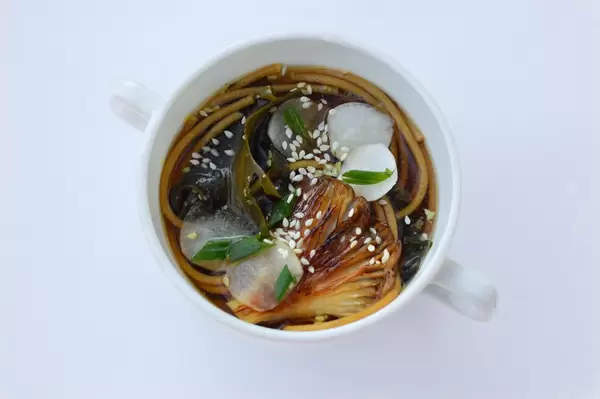 Suppe mit Seetang und Pilzen auf weißem Hintegrund