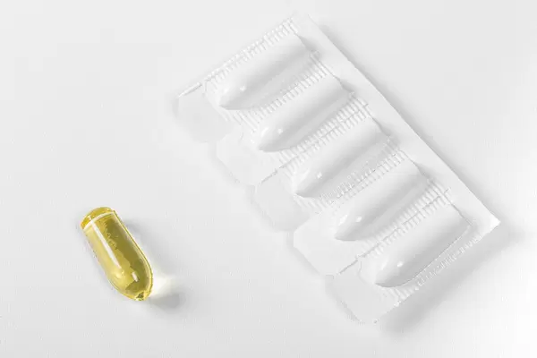 Suppositories in blister and one without packaging on white background (Flip 2019)