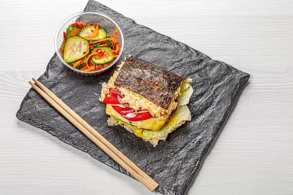 Sushi Burger on black background with spicy vegetables. Top view (Flip 2019)