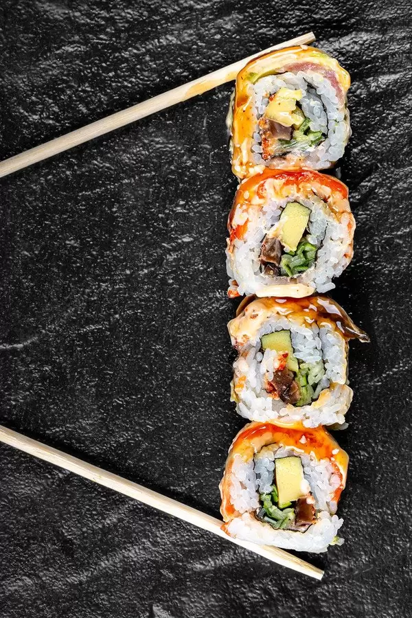 Sushi Rainbow Dragon on a black background with chopsticks