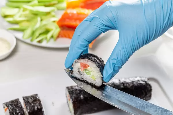 Sushi roll making preparation, close up on chef hands with a knife (Flip 2019)