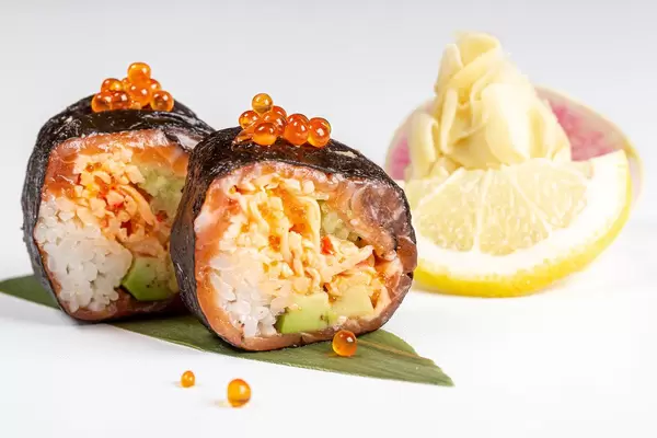 Sushirollen mit Nori Räucherlachs, Krabbenfleisch, Avocado, Reis, roter Kaviar und Microgreens
