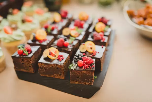 Süße Nachspeise: Brownie-Quadraten mit verschiedenen Beeren verziert