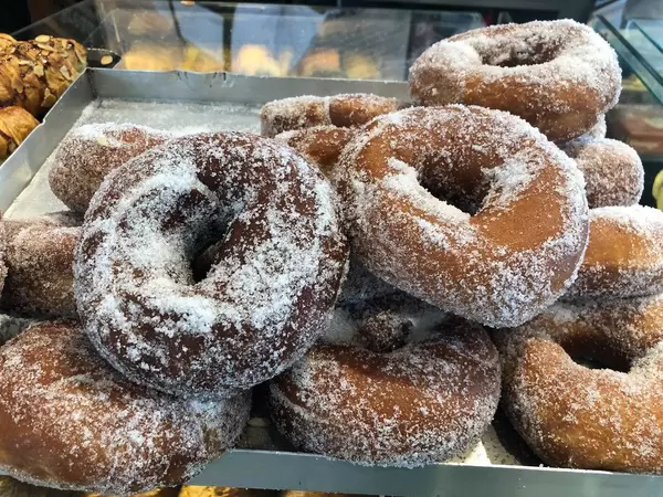 Süßes Gebäck: Gezuckerte Donuts auf einem Blech in einer Bäckerei in Griechenland