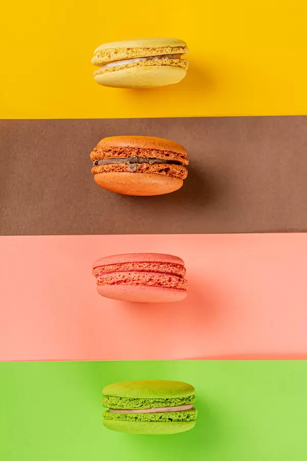 Sweet and colourful french macaroons on a colored background, top view