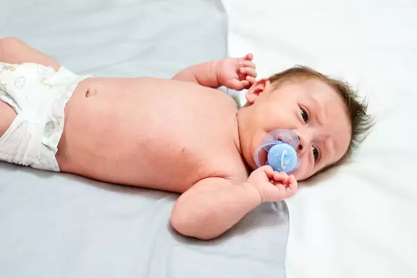 Sweet baby lying on the bed with soother