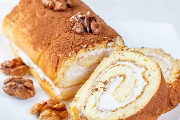 Sweet biscuit roll with cream and walnuts
