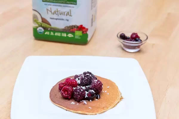 Sweet brunch with pancake, raspberries and coconut rasps