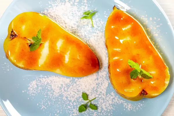 Sweet dessert with pears in caramel sauce on a blue plate (Flip 2019)