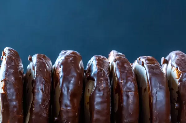 Sweet gingerbread in chocolate icing on a dark background